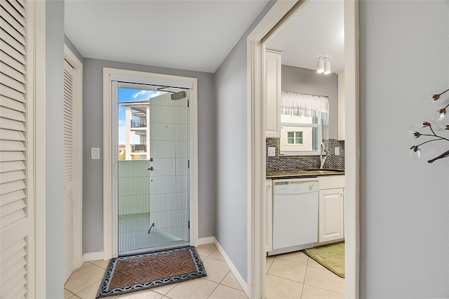 entryway featuring plenty of natural light, light tile patterned flooring, and sink