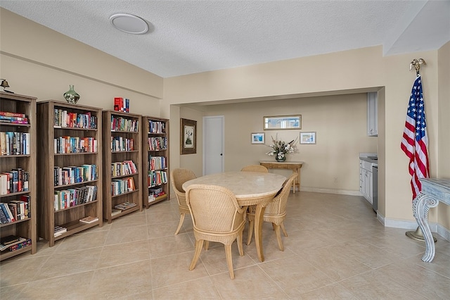 dining area featuring light tile patterned flooring and a textured ceiling