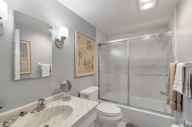 full bathroom featuring shower / bath combination with glass door, tile patterned flooring, vanity, and toilet