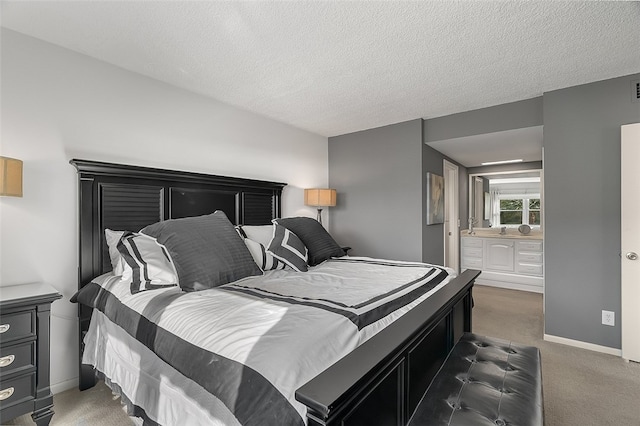 bedroom with dark colored carpet, a textured ceiling, and ensuite bath