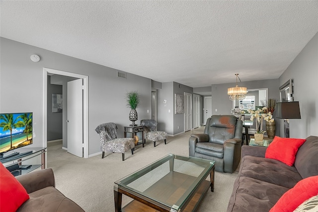 carpeted living room with a notable chandelier and a textured ceiling