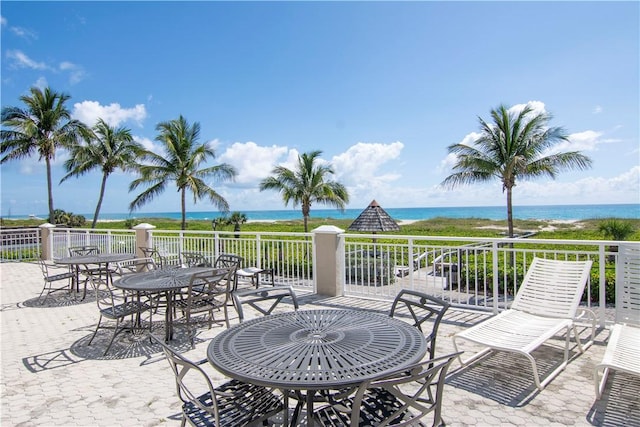 view of patio featuring a beach view and a water view