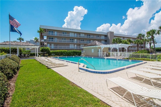 view of pool with a lawn, a patio area, and a pergola