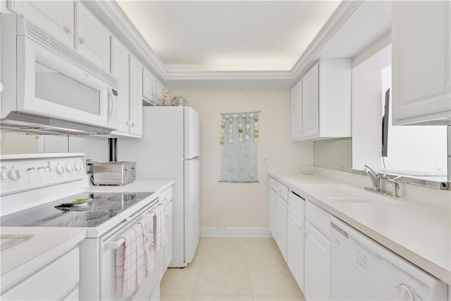 kitchen with white appliances, a tray ceiling, sink, white cabinetry, and light tile patterned flooring