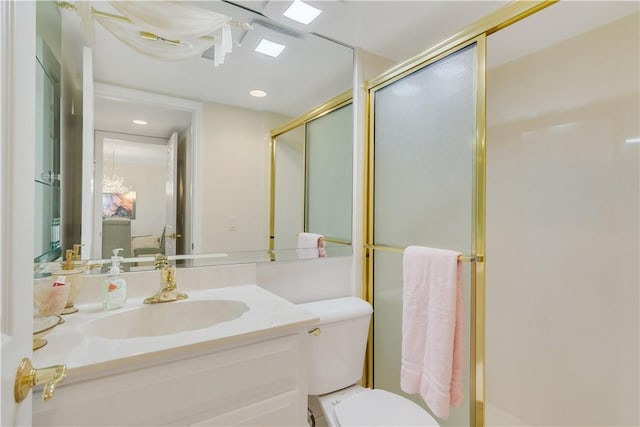 bathroom with vanity, toilet, and a shower with shower door