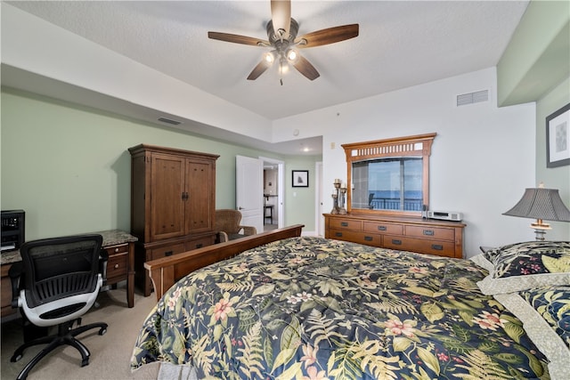 carpeted bedroom featuring ceiling fan and a textured ceiling