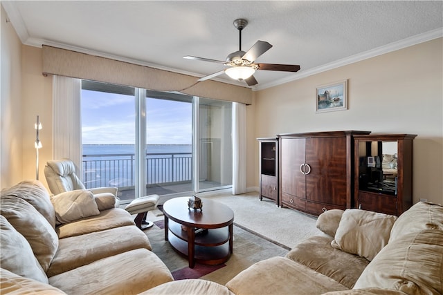 carpeted living room featuring a textured ceiling, ornamental molding, ceiling fan, and a water view