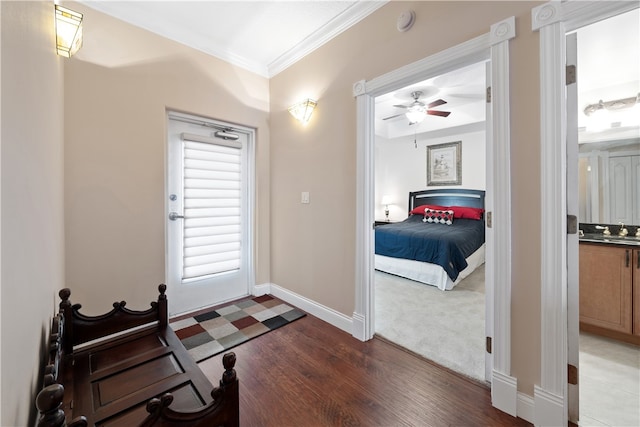 interior space with ornamental molding, ceiling fan, and dark hardwood / wood-style flooring