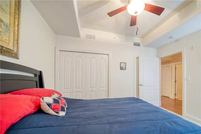 bedroom featuring hardwood / wood-style flooring, ceiling fan, and a closet