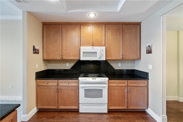 kitchen with white appliances, dark hardwood / wood-style floors, and dark stone counters