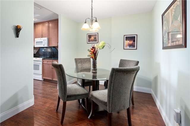 dining room with dark hardwood / wood-style flooring and a notable chandelier