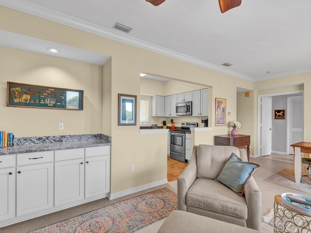 tiled living room with ceiling fan and crown molding