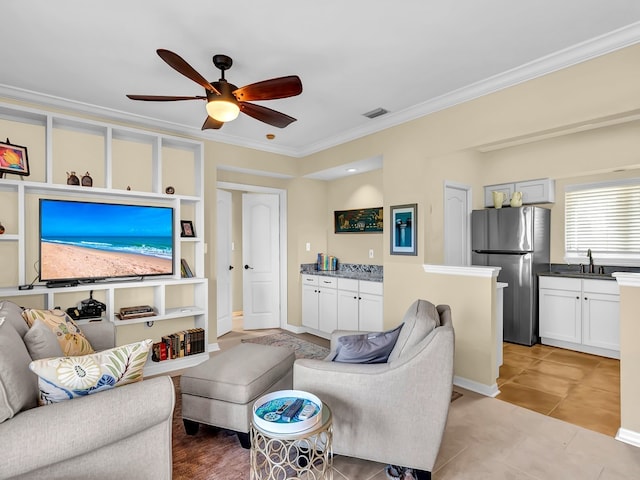 living room with ceiling fan, ornamental molding, sink, and light tile patterned floors