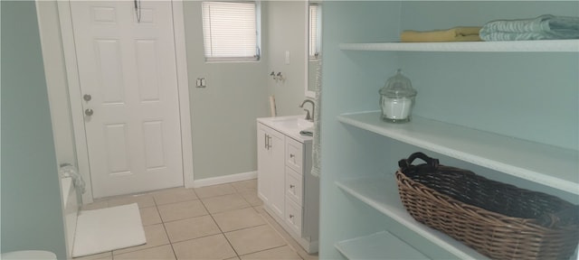 full bath with baseboards, vanity, and tile patterned floors