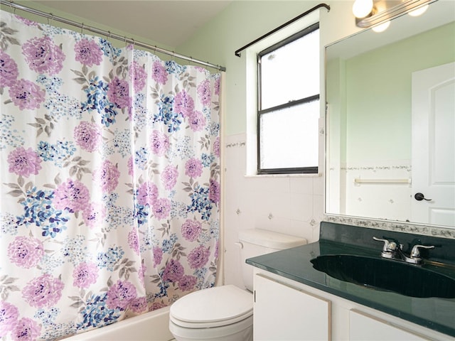 bathroom featuring vanity, toilet, and tile walls