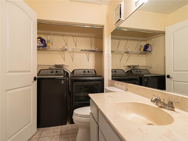 bathroom with washer and clothes dryer, vanity, toilet, and tile patterned flooring