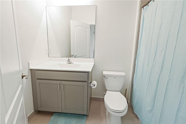 10011 W Villa Cir, Vero Beach, FL 32966 - bathroom with vanity, toilet, baseboards, tile patterned flooring, and a shower with curtain