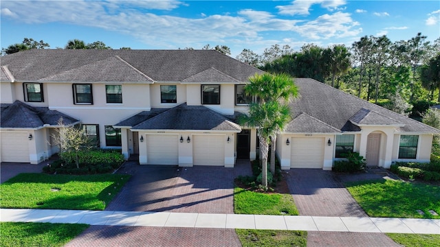 10011 W Villa Cir, Vero Beach, FL 32966 - view of front of property with an attached garage, decorative driveway, stucco siding, and a front lawn
