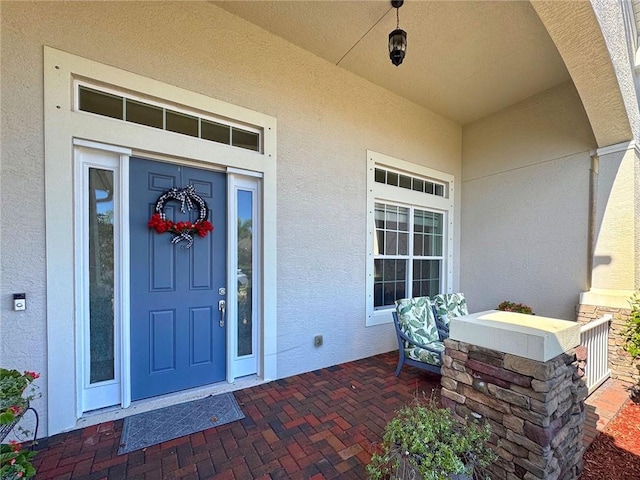 view of exterior entry featuring covered porch