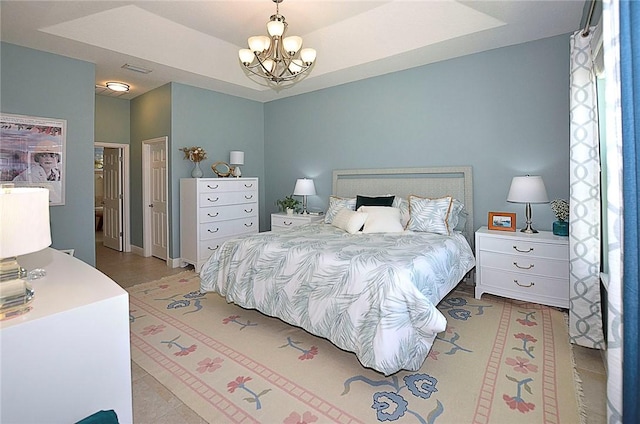 bedroom featuring a raised ceiling and an inviting chandelier