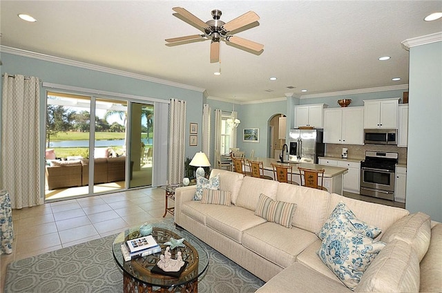 tiled living room featuring ceiling fan, ornamental molding, and sink