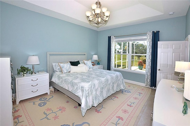 bedroom with a chandelier and a tray ceiling