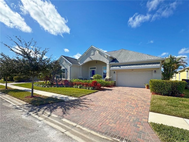 ranch-style home featuring a garage and a front lawn