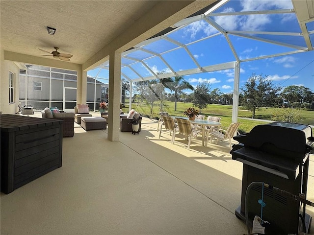 view of patio with outdoor lounge area, glass enclosure, a grill, and ceiling fan