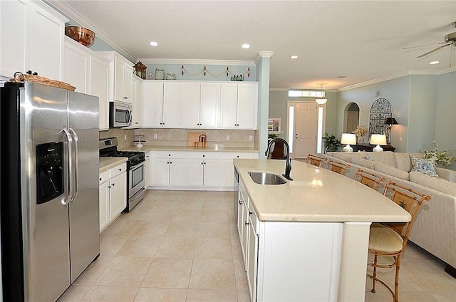 kitchen featuring sink, decorative backsplash, ornamental molding, white cabinetry, and stainless steel appliances