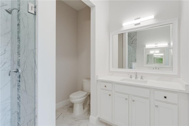 bathroom featuring toilet, marble finish floor, a marble finish shower, and vanity