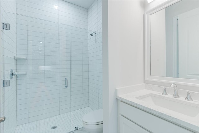 bathroom featuring toilet, a stall shower, and vanity