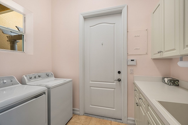 laundry area featuring a sink, cabinet space, light tile patterned flooring, and washer and clothes dryer