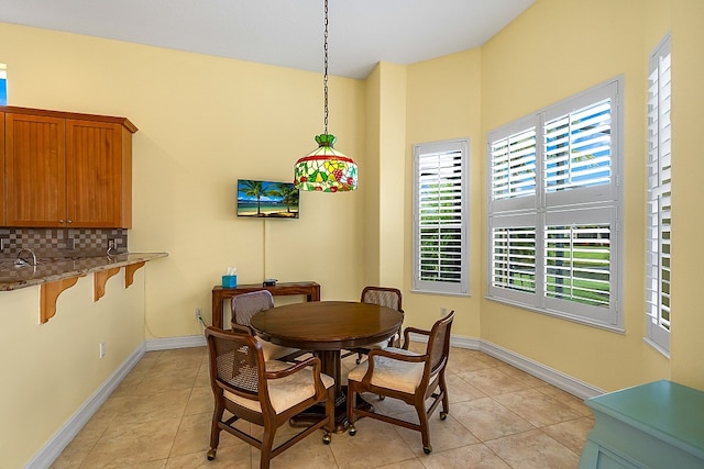 dining area featuring light tile patterned floors and baseboards