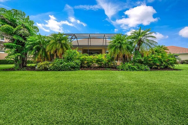 4336 Summer Breeze Ter, Vero Beach, FL 32967 - back of property featuring a lawn and glass enclosure