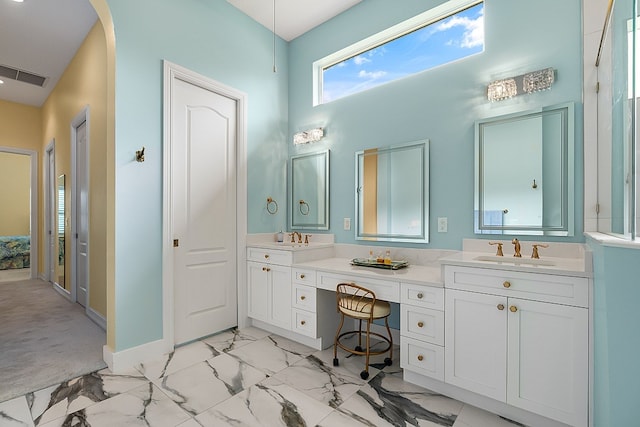 bathroom featuring a sink, visible vents, marble finish floor, and double vanity