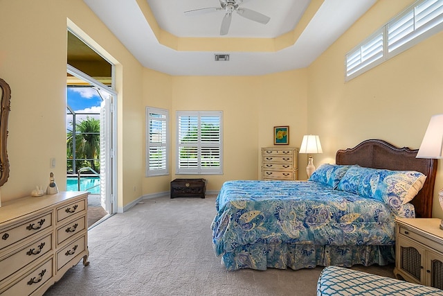 bedroom with visible vents, a tray ceiling, carpet floors, baseboards, and access to exterior