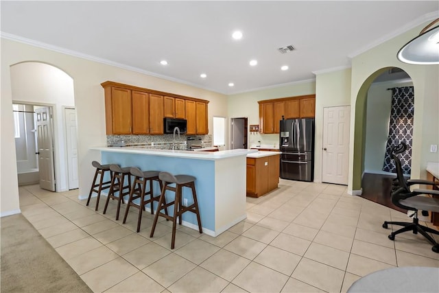 6029 Winfield Dr, Port St Lucie, FL 34986 - kitchen with light countertops, brown cabinetry, a peninsula, fridge with ice dispenser, and visible vents