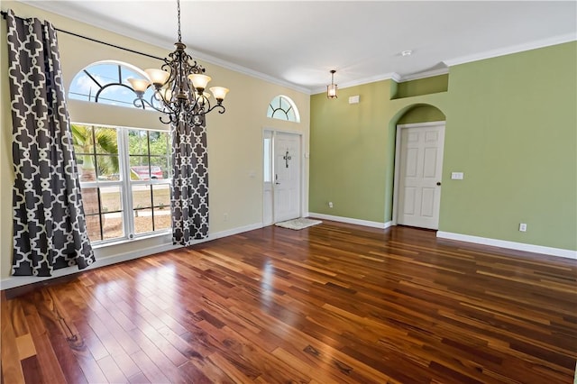 6029 Winfield Dr, Port St Lucie, FL 34986 - interior space featuring arched walkways, a chandelier, baseboards, dark wood-type flooring, and ornamental molding