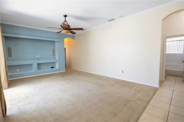 6029 Winfield Dr, Port St Lucie, FL 34986 - unfurnished room with crown molding, built in features, light carpet, ceiling fan, and arched walkways