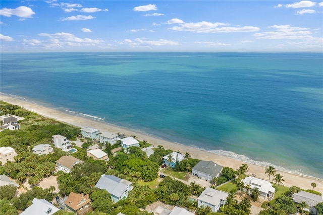 birds eye view of property with a water view and a beach view