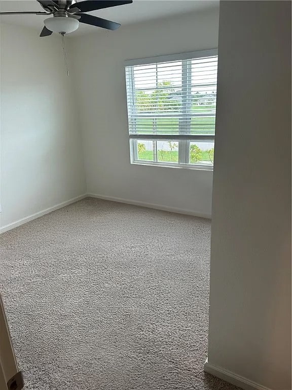 spare room featuring carpet flooring and ceiling fan