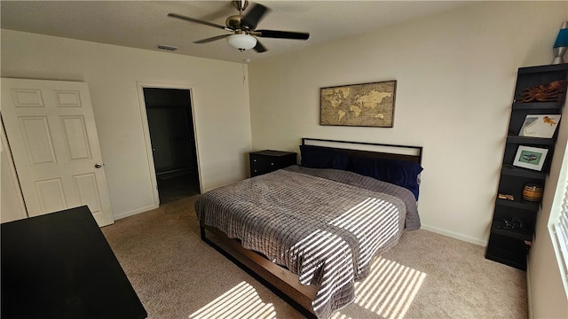 carpeted bedroom with ceiling fan and ensuite bath