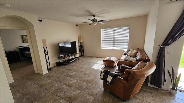 living room with a textured ceiling and ceiling fan