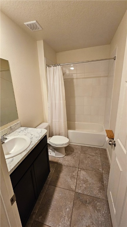 full bathroom with vanity, a textured ceiling, toilet, and shower / tub combo