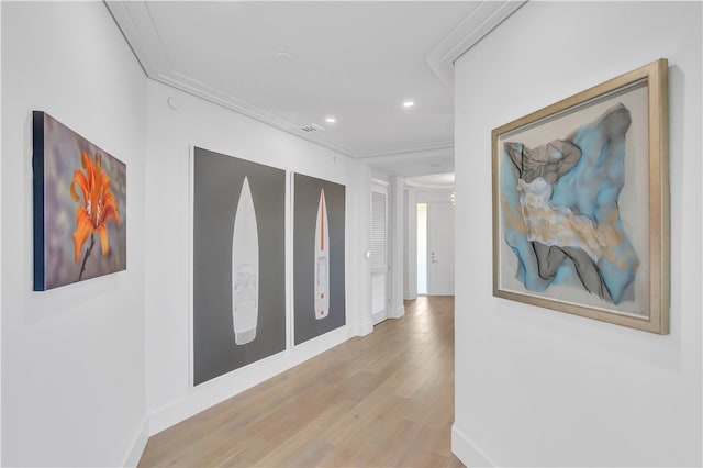 hall featuring crown molding and light hardwood / wood-style flooring