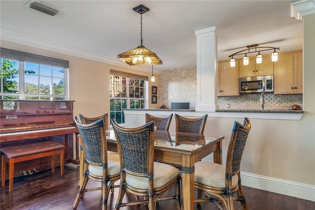 dining area with ornamental molding, dark hardwood / wood-style flooring, and decorative columns