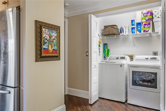 laundry room featuring washer and clothes dryer, dark hardwood / wood-style flooring, and crown molding