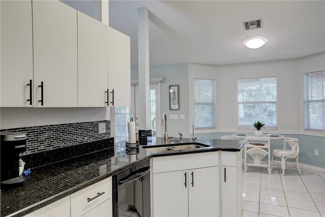 kitchen with white cabinetry, sink, dark stone counters, light tile patterned floors, and dishwasher