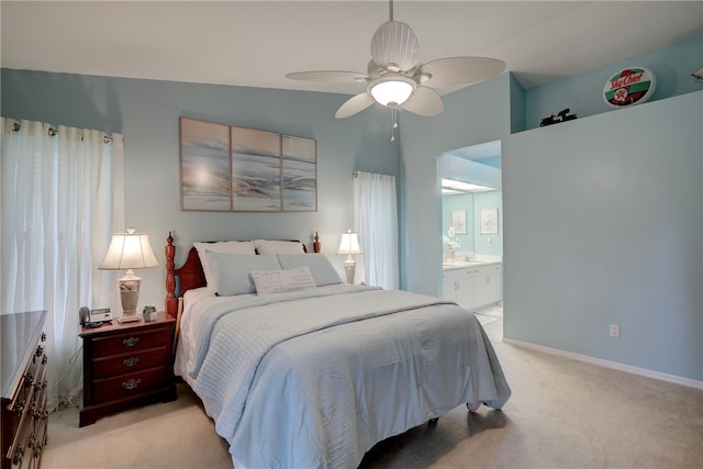 bedroom with ceiling fan, connected bathroom, light carpet, and lofted ceiling