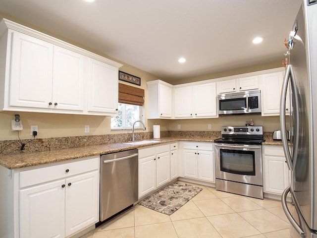 4368 56th Ln, Vero Beach, FL 32967 - kitchen with stainless steel appliances, white cabinets, light tile patterned flooring, recessed lighting, and light stone countertops
